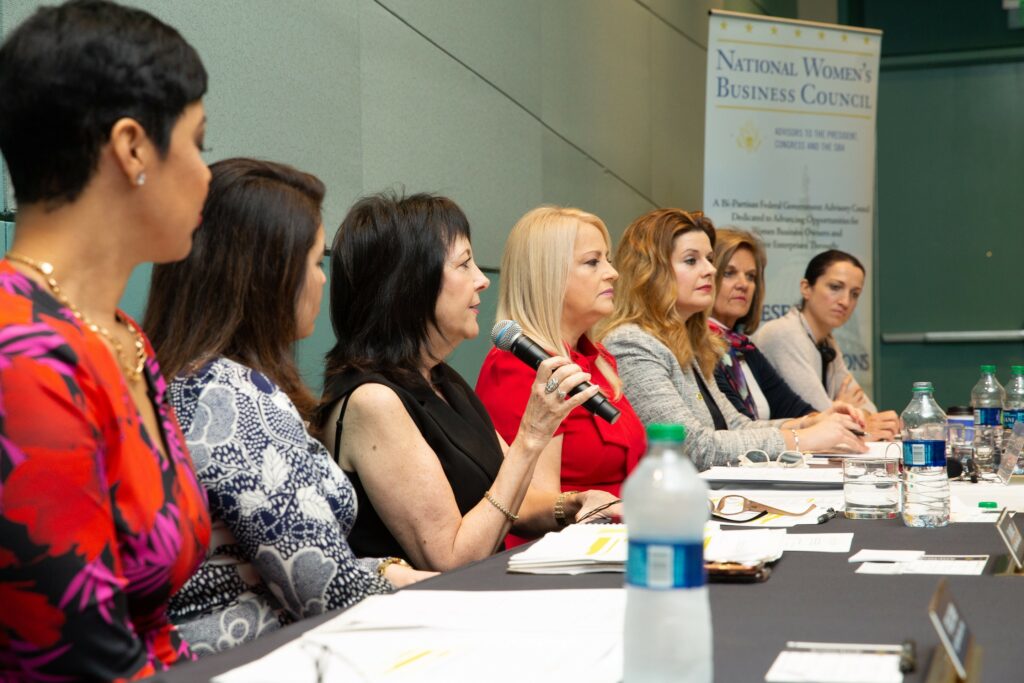 A group of women sitting at a long table.